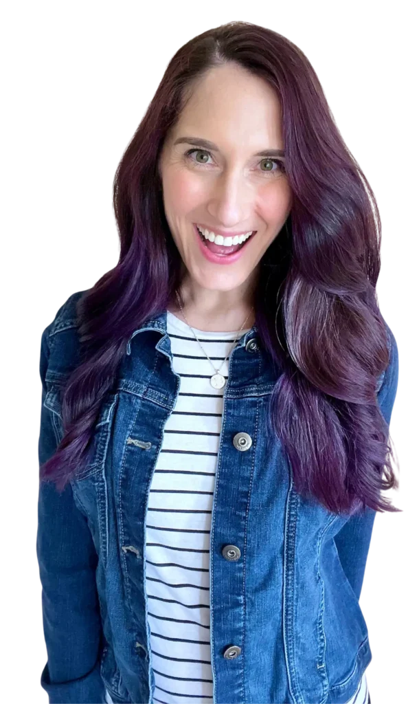 Paula with purple hair wearing a denim jacket and striped shirt