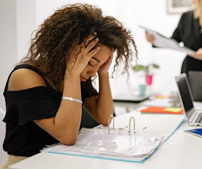 Woman with hands on head, overwhelmed by cognitive overload and ADHD. Tips to handle overwhelm.